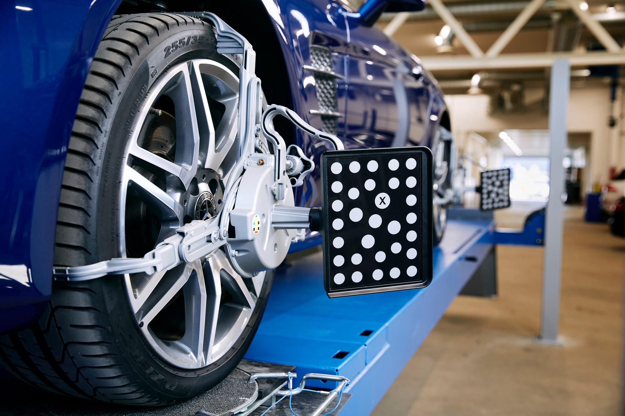 Bil på verksted med hjuljusteringsutstyr