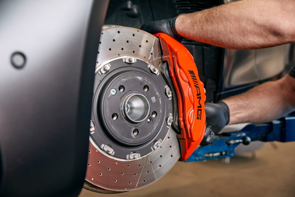 Rød bremsekaliper og bremseskive på bil.