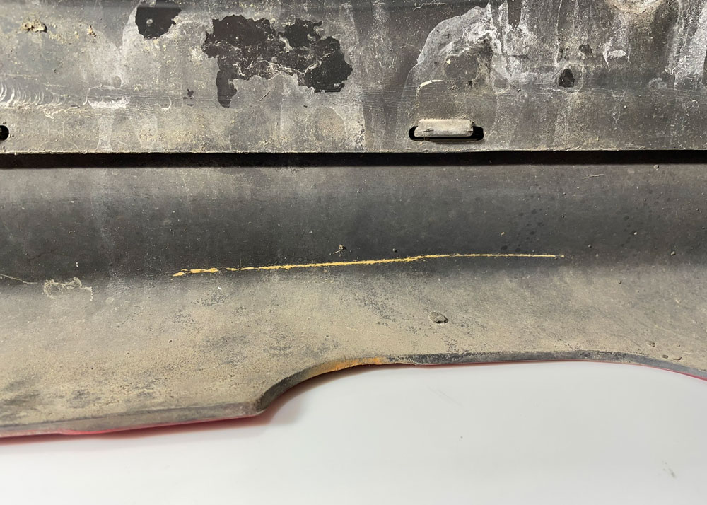 Rip i gammel sort metalloverflate