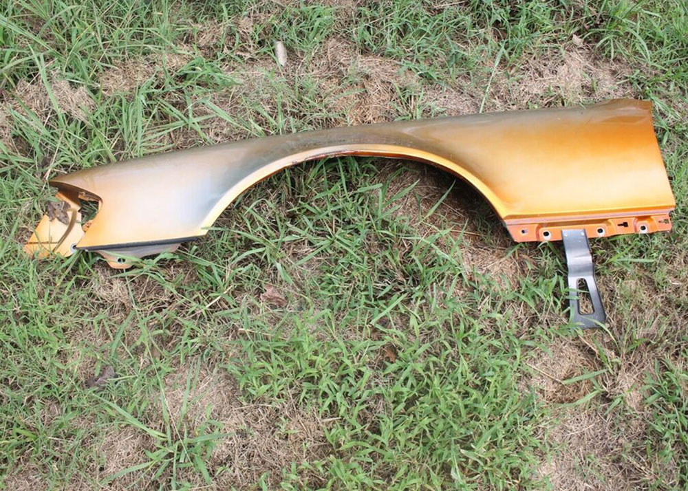 Gul bilskjerm liggende på gresset