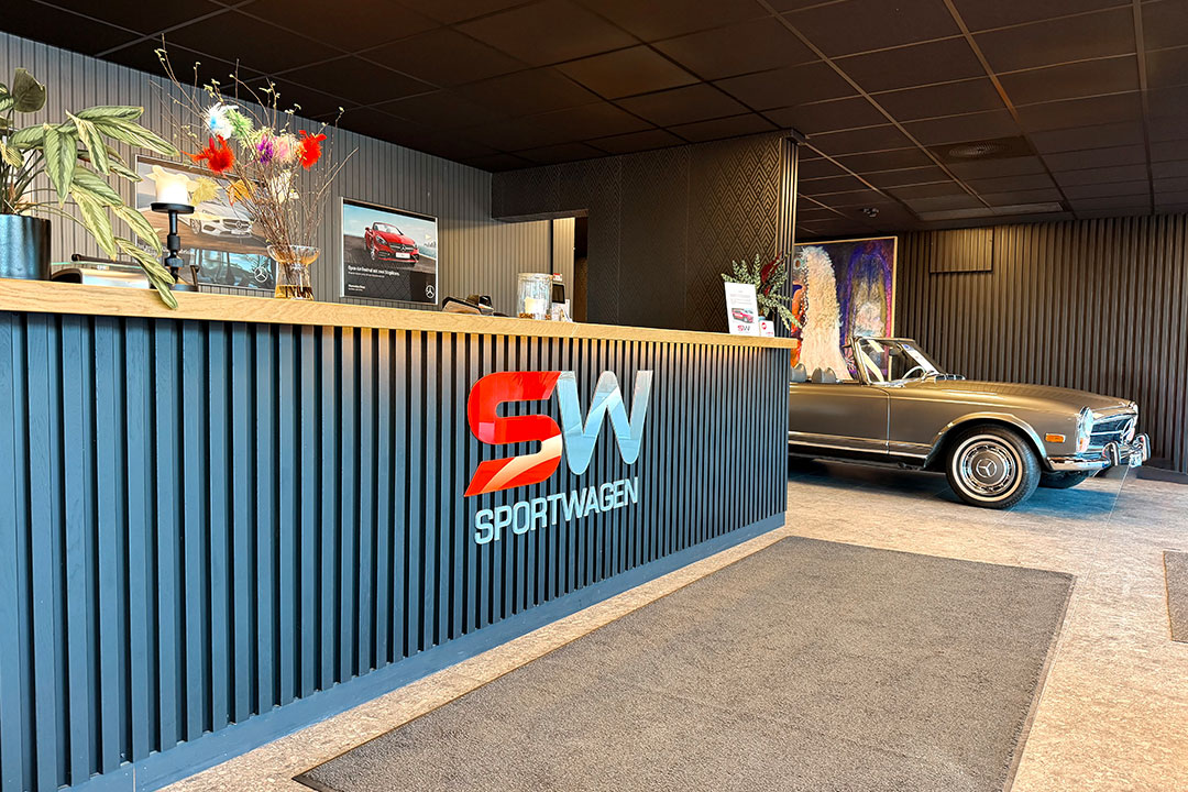 Moderne bilforhandler med stående klassisk bil inne.